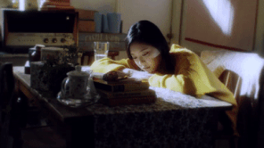 A pink-tinted gif of hands putting a tape into a portable tape-player. One finger goes to click the play button.